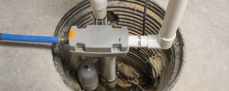 Close up of a sump pump installed in a home basement for domestic plumbing use