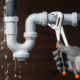 Close up of a plumber fixing a water leak in a sink drain siphon pipe.