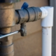 Using a flathead screwdriver to close the test cock when winterizing backflow preventer