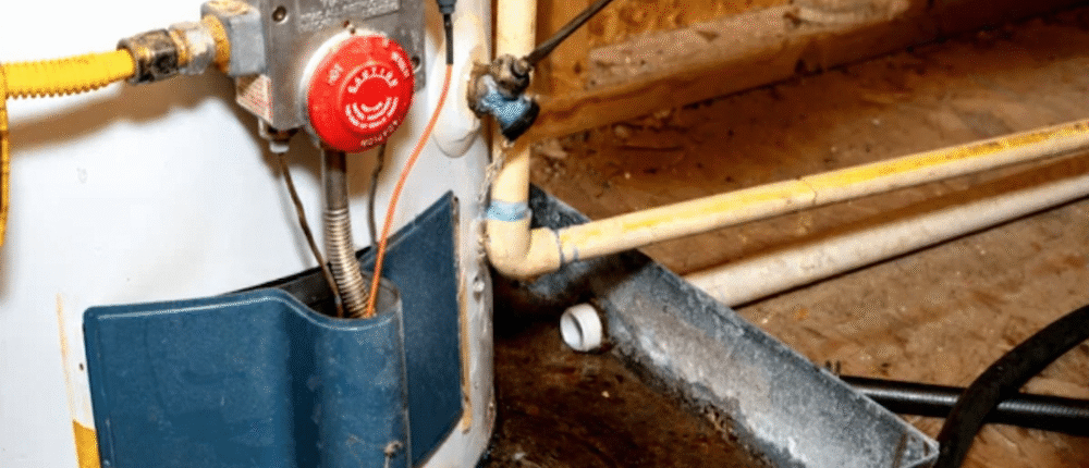 A technician repairing a residential electric water heater in a utility room.